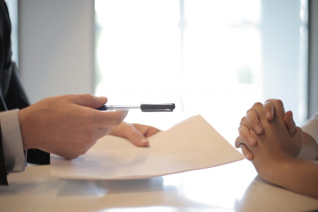 holding-contract-hands-folded-on-table-window